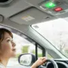 シエンタの運転席からSOSボタンを見上げる女性。ボタンは緑色に点灯しており、安全な状態を示している。