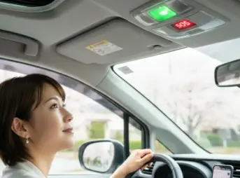 シエンタの運転席からSOSボタンを見上げる女性。ボタンは緑色に点灯しており、安全な状態を示している。