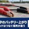駐車場の地面に置かれた赤と黒のブースターケーブルを写したタイトル画像
