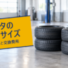 明るい整備工場の床に2段ずつ重ねて置かれた新品のタイヤ4本