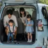 トヨタシエンタの広い荷室で楽しそうに過ごす日本人家族。両親と子供二人が車の中でくつろいでいる。