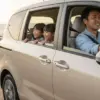 家族で長距離ドライブを楽しむシエンタ。運転席の日本人男性ドライバーは笑顔で、助手席の妻と後部座席の子供たちも楽しそうだ。
