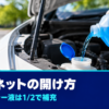 ボンネットを少し開けた車にウォッシャー液を注ぐ手元