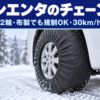 雪道に止めたミニバンの前輪にかぶせた布製のタイヤチェーン