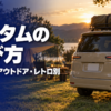 夕方のキャンプ場の芝生に停めたルーフラック付きミニバンの斜め後ろ姿