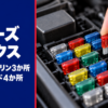 ふたを外したヒューズボックスから平型ヒューズを指でつまむ手元