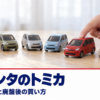 木のテーブルに並んだ小さなミニカーと子どもの手元