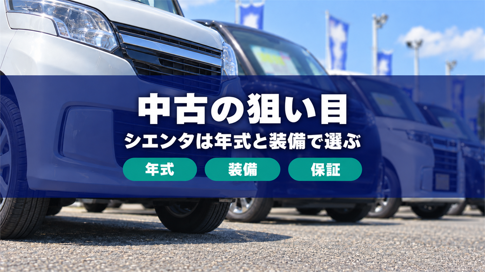 屋外の中古車展示場に並ぶコンパクトミニバンを低い位置から写した写真