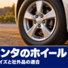 夕方の舗装路で斜めから写したミニバンのシルバーの5本スポークのアルミホイール